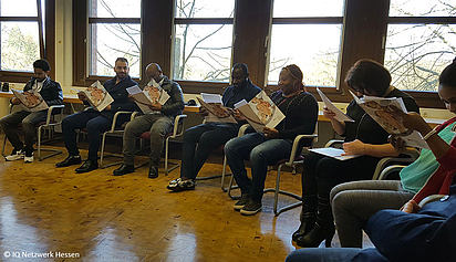 Teilnehmende des IQ Projekts First Step studieren ihre Zertifikate.